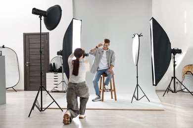 Photo of Photographer working with model in professional photo studio