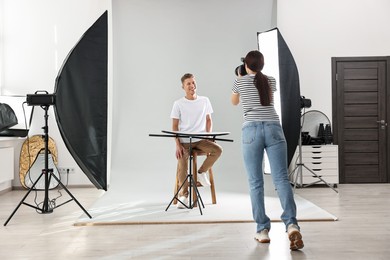 Photo of Photographer working with model in professional photo studio