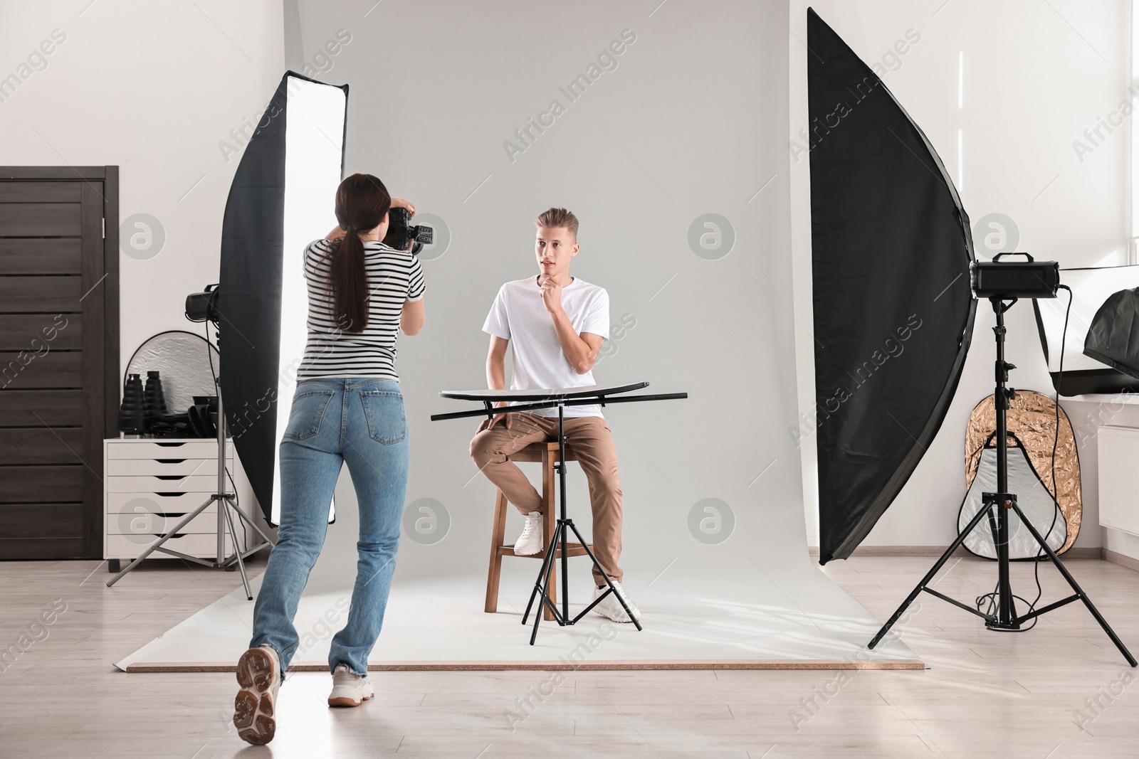 Photo of Photographer working with model in professional photo studio