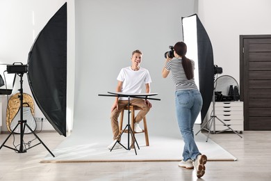 Photographer working with model in professional photo studio