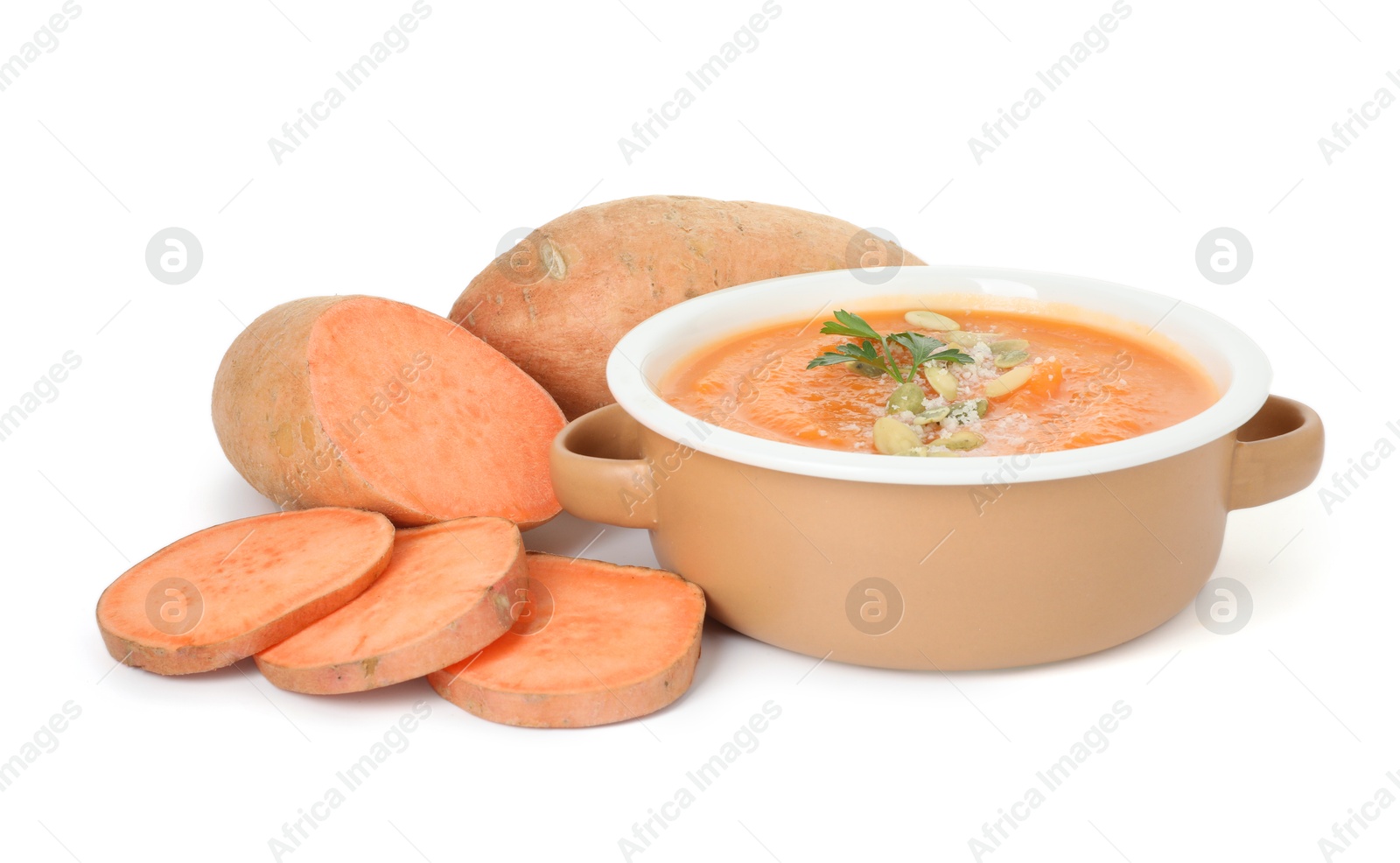 Photo of Delicious sweet potato soup with pumpkin seeds in bowl and fresh vegetable isolated on white