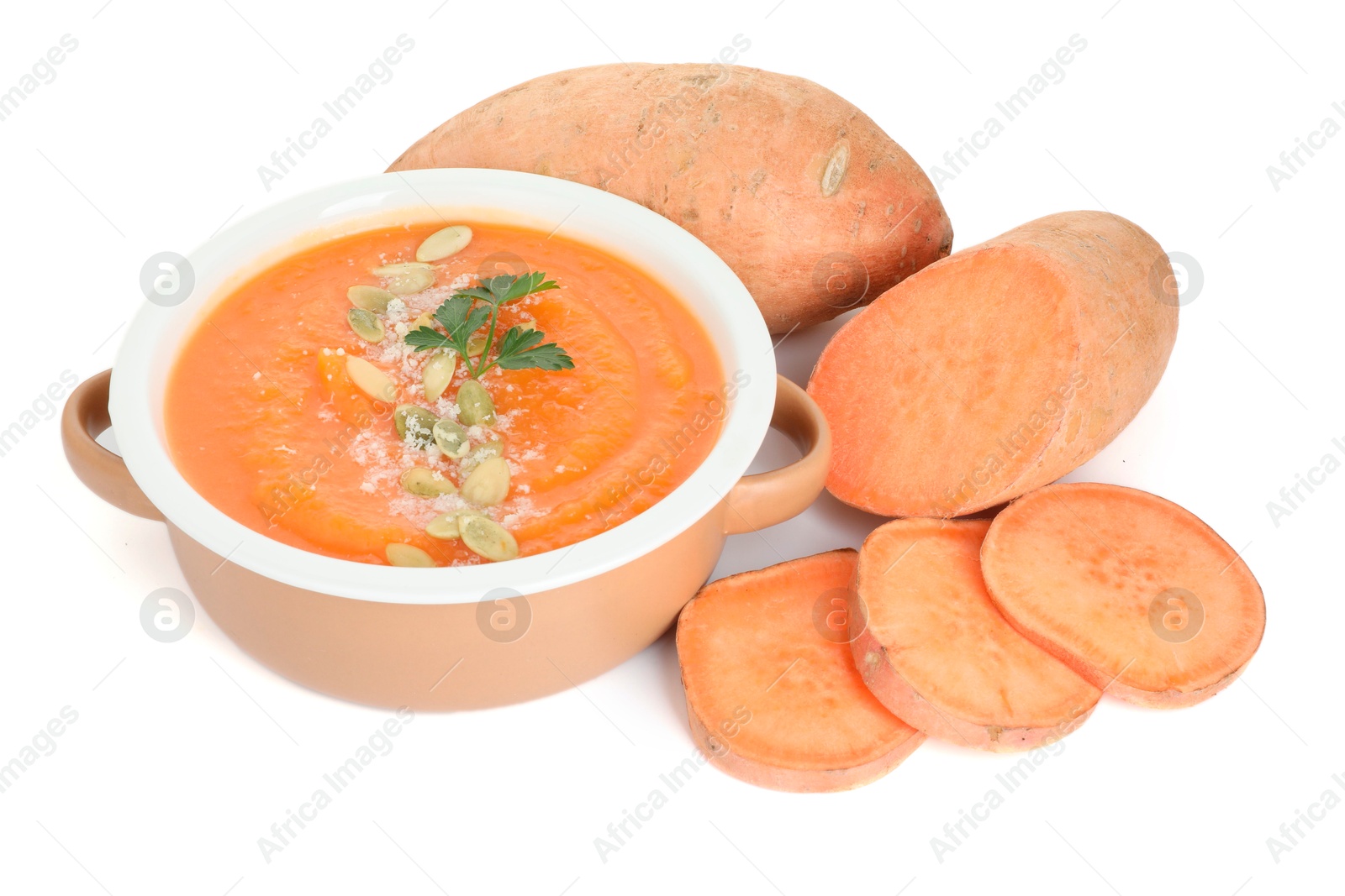 Photo of Delicious sweet potato soup with pumpkin seeds in bowl and fresh vegetable isolated on white