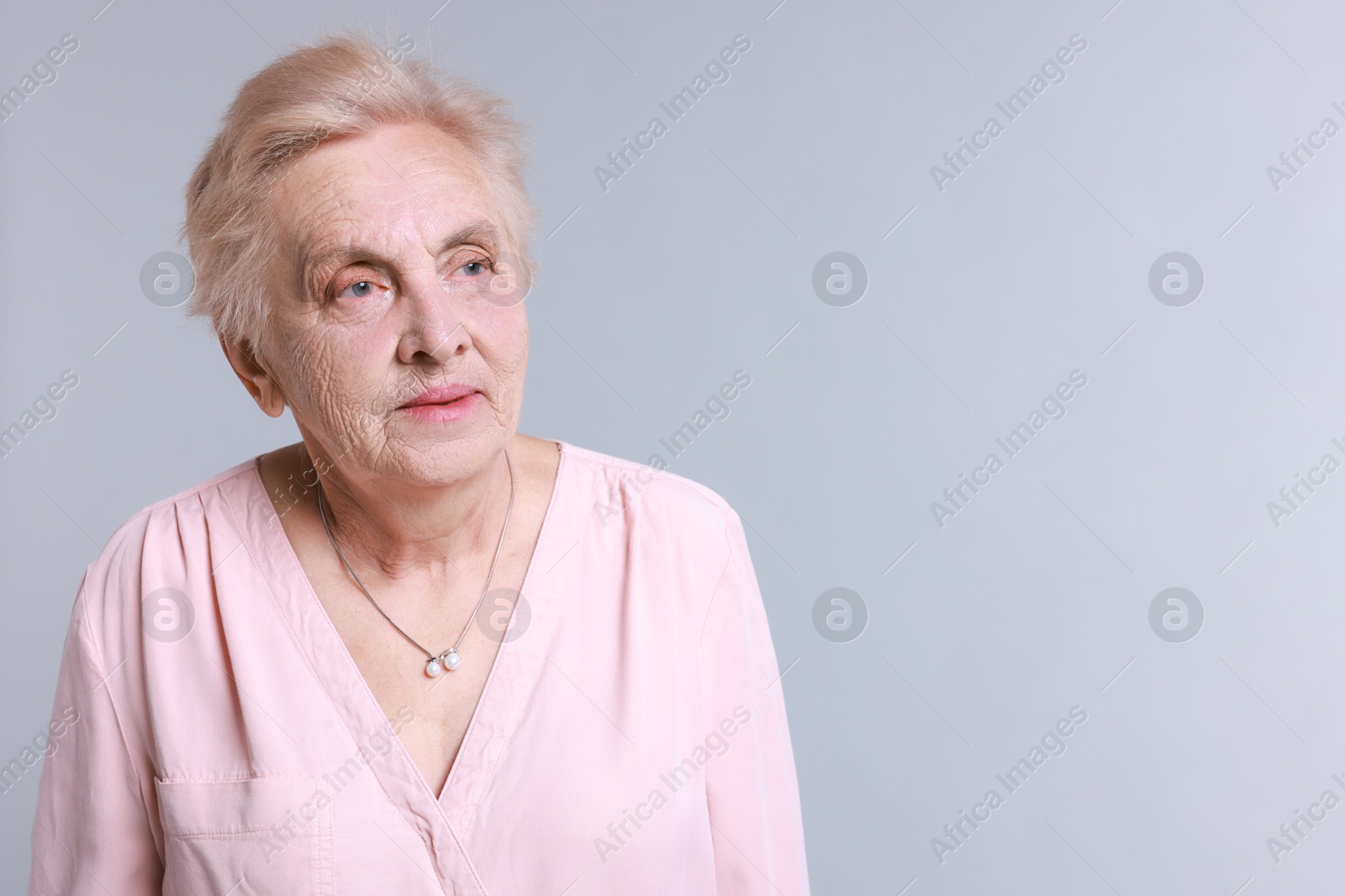 Photo of Portrait of senior woman on light background. Space for text