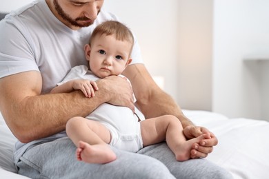 Photo of Father with his little baby on bed at home, closeup