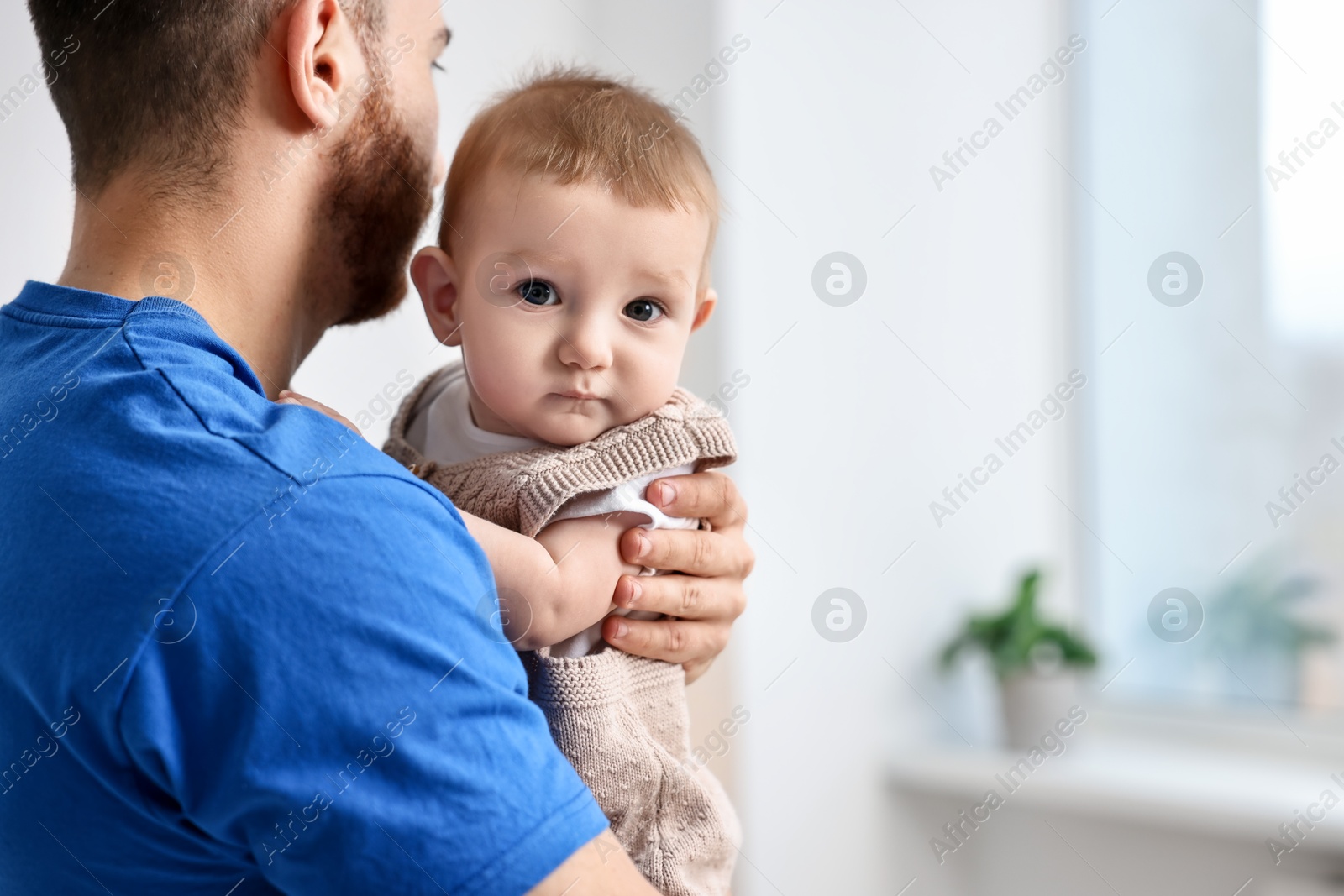 Photo of Dad with his cute little baby at home, closeup. Space for text