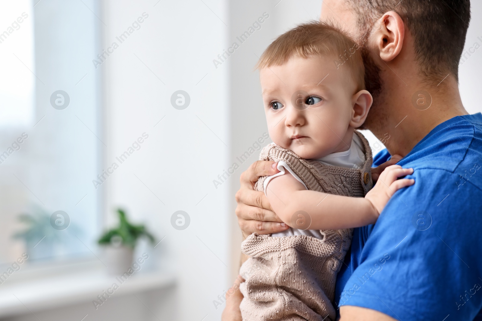 Photo of Dad with his cute little baby at home, closeup. Space for text