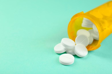 Photo of Medical bottle with antibiotic pills on yellow background, closeup. Space for text