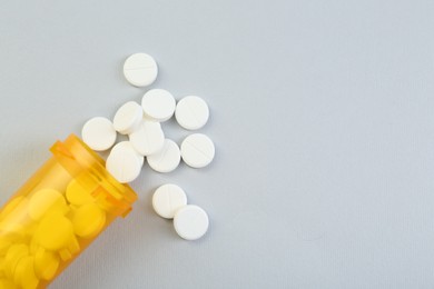 Photo of Antibiotic pills and medical bottle on grey background, top view. Space for text