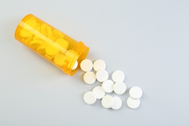 Photo of Antibiotic pills and medical bottle on grey background, top view