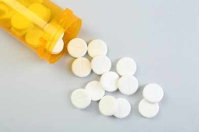 Photo of Antibiotic pills and medical bottle on grey background, top view