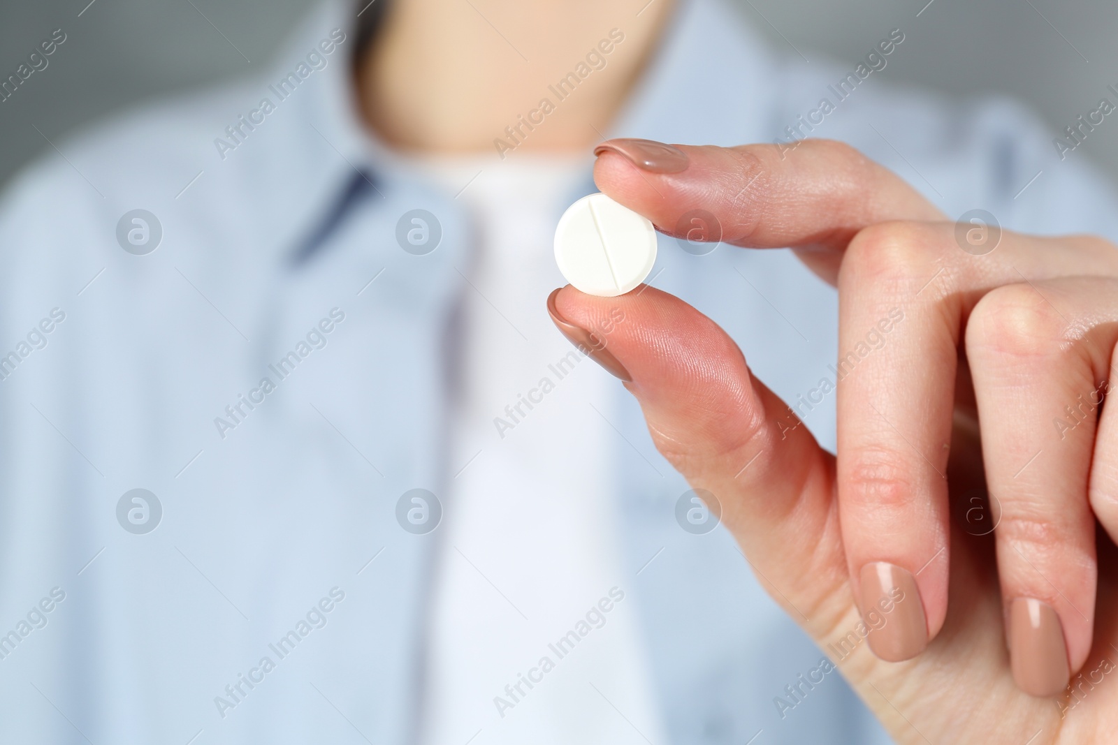 Photo of Woman holding antibiotic pill, closeup. Selective focus