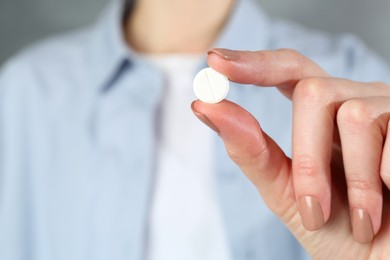 Photo of Woman holding antibiotic pill, closeup. Selective focus