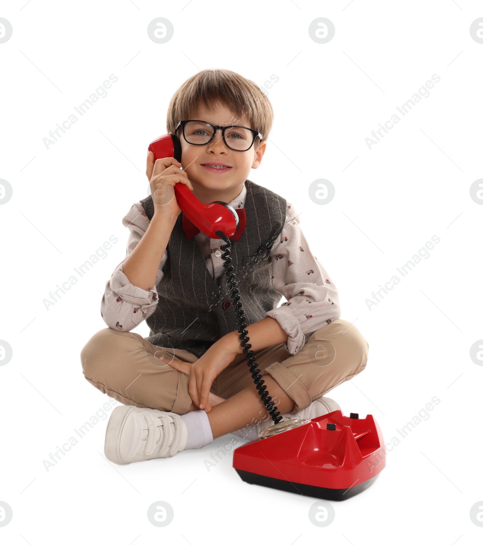 Photo of Cute little boy with old telephone on white background