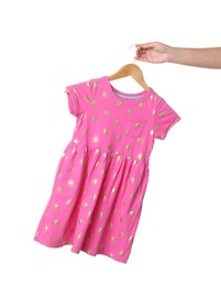 Photo of Woman holding hanger with pink baby dress on white background, closeup