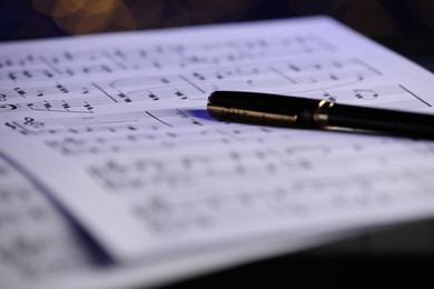 Sheets of musical notes and pen as background, closeup