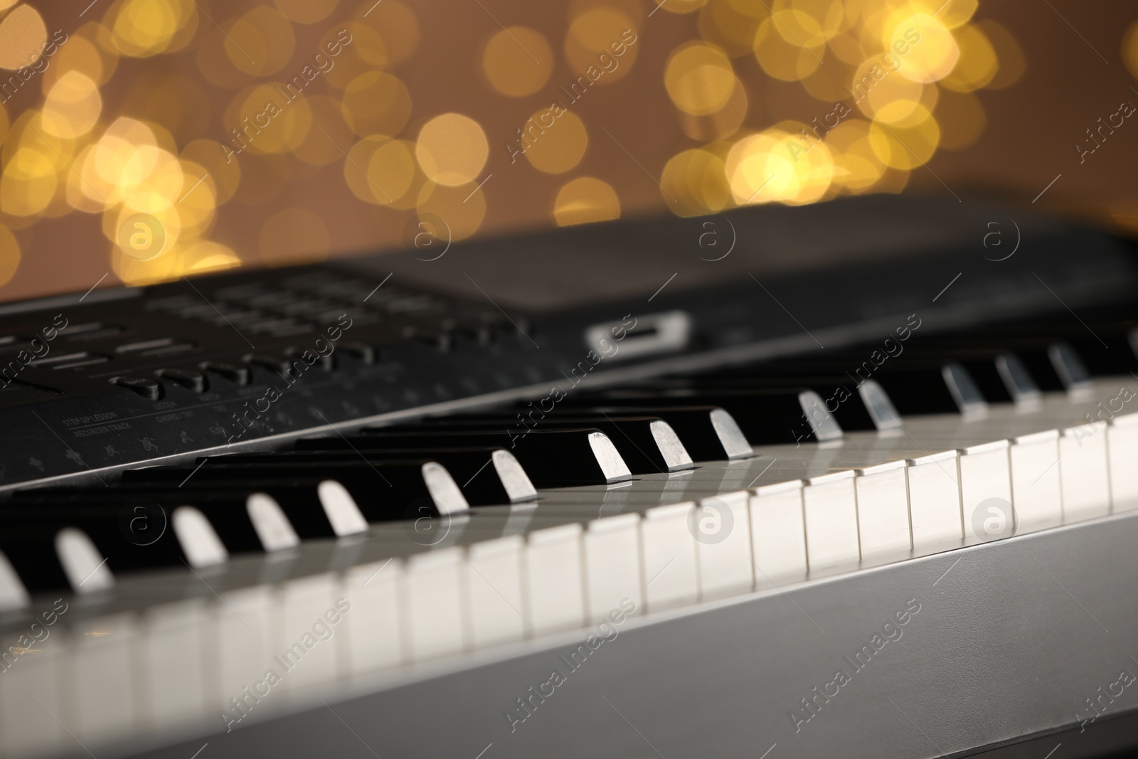 Photo of Piano against blurred lights, closeup. Bokeh effect