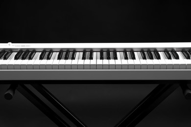 Photo of Synthesizer on black background, closeup. Electronic musical instrument