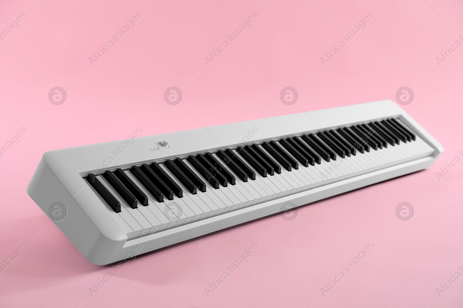 Photo of Synthesizer on pink background, closeup. Electronic musical instrument