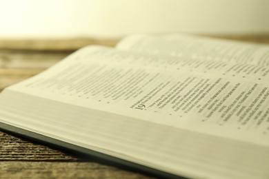 Open Holy Bible in English language on wooden table, closeup