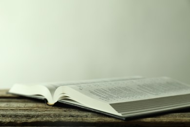 Open Holy Bible in English language on wooden table, closeup