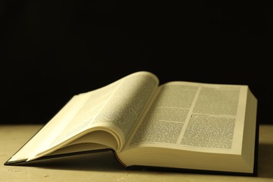 Open Holy Bible in English language on beige table