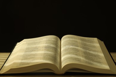 Open Holy Bible in English language on table, closeup