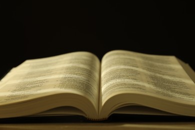 Open Holy Bible in English language on table, closeup