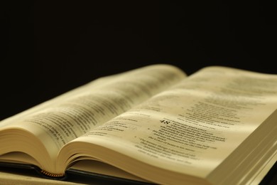 Open Holy Bible in English language on table, closeup