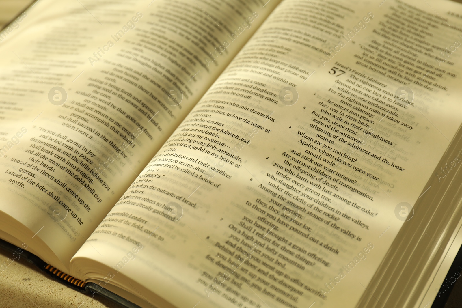 Photo of Open Holy Bible in English language on table, closeup