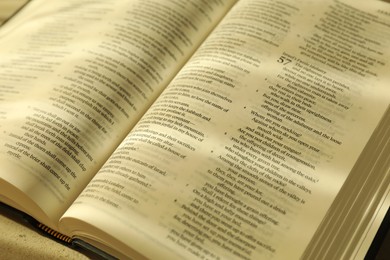 Open Holy Bible in English language on table, closeup