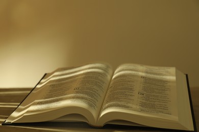 Photo of Open Holy Bible in English language on table, closeup