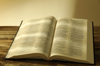 Open Holy Bible in English language on wooden table