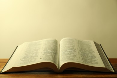 Photo of Open Holy Bible in English language on wooden table