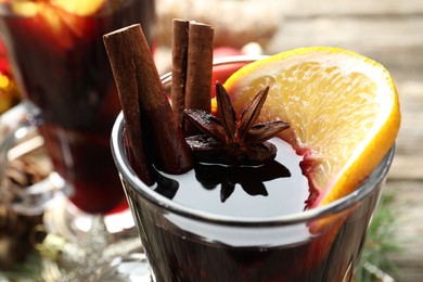 Photo of Tasty mulled wine with spices on table, closeup. Christmas drink