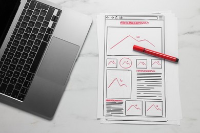 Developing UI design. Sketches of website wireframes, laptop and felt pen on white marble table, top view