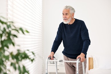 Senior man with walking frame in hospital ward