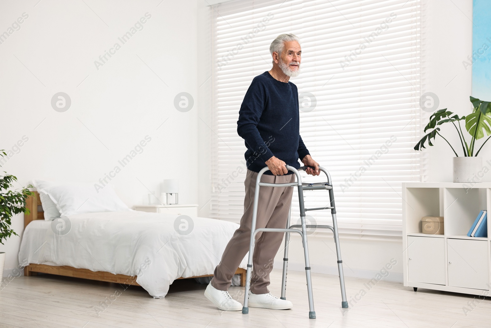 Photo of Senior man with walking frame in hospital ward