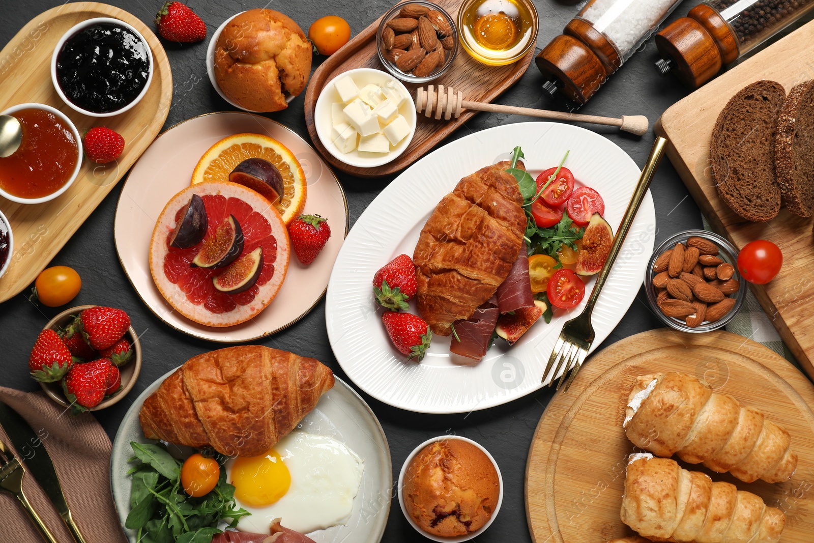 Photo of Different tasty food served for brunch on grey textured table, flat lay