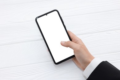 Photo of Woman unlocking smartphone with fingerprint scanner at white wooden table, closeup