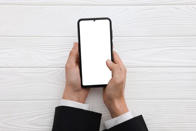 Photo of Woman unlocking smartphone with fingerprint scanner at white wooden table, top view