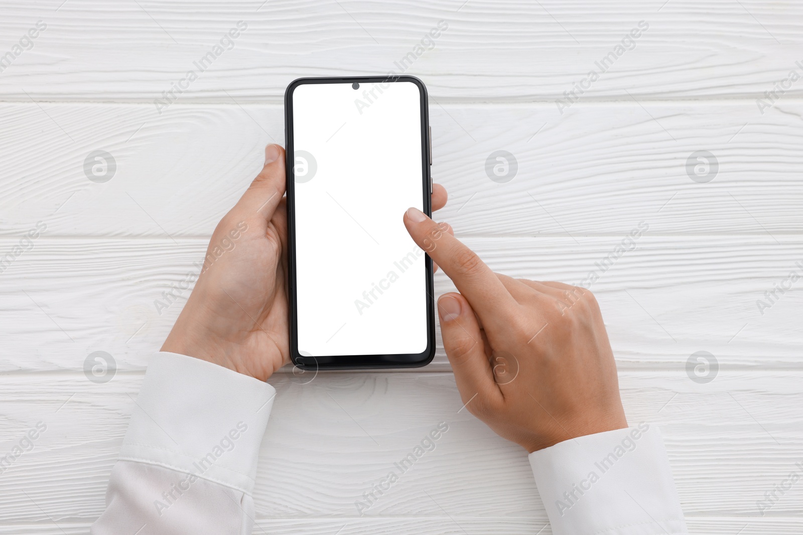 Photo of Woman unlocking smartphone with fingerprint scanner at white wooden table, top view