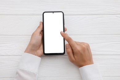 Photo of Woman unlocking smartphone with fingerprint scanner at white wooden table, top view