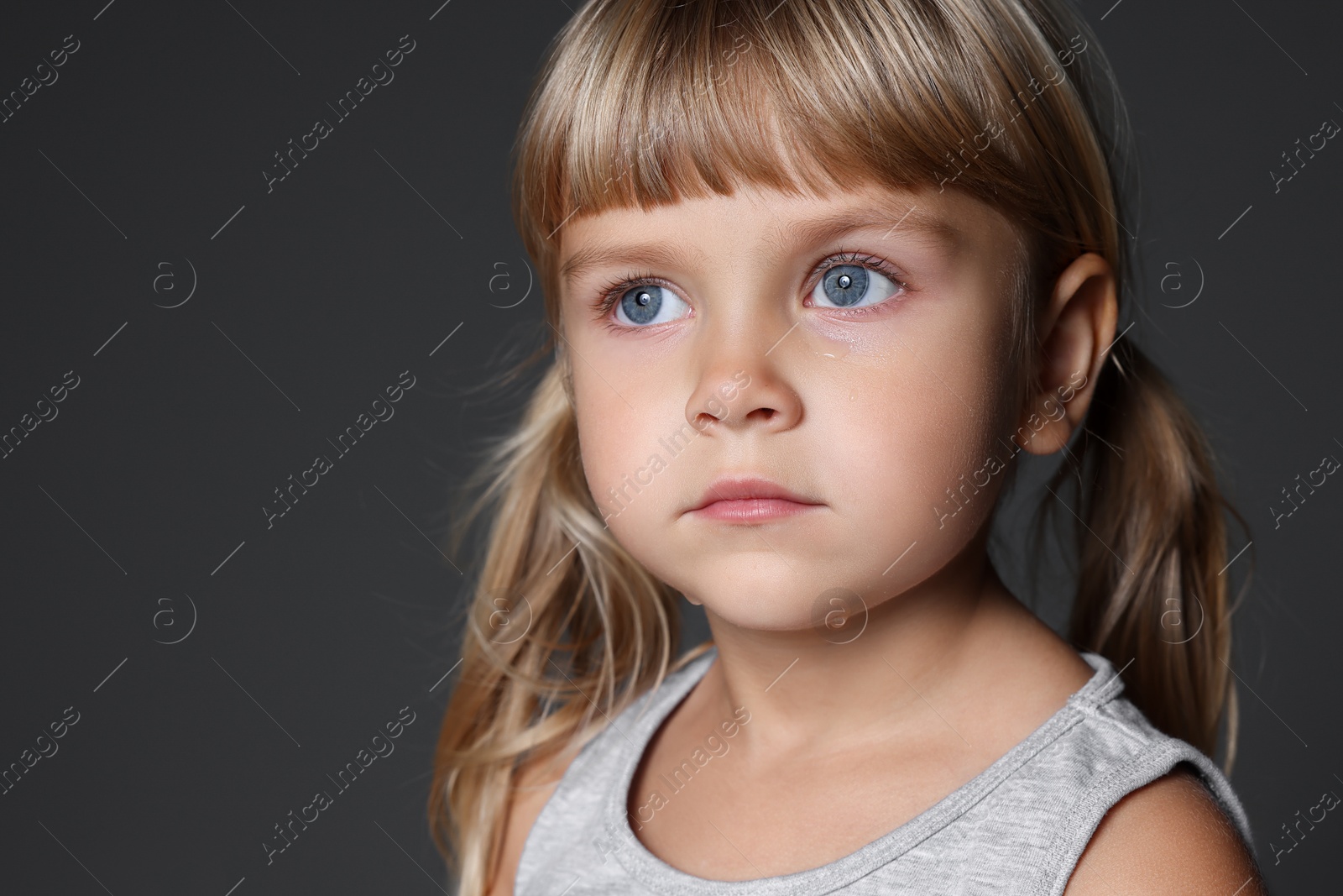 Photo of Orphanage concept. Sad little girl on grey background