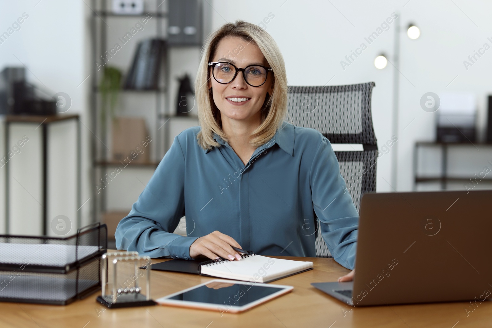 Photo of Businesswoman working on laptop at table in office