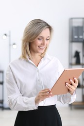 Photo of Portrait of happy businesswoman using tablet in office