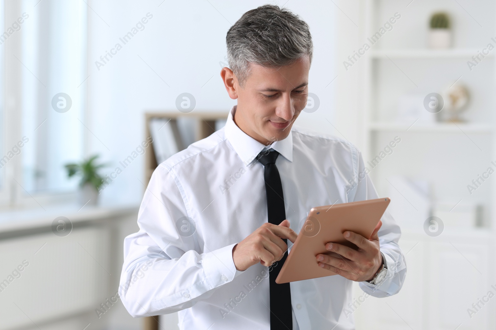 Photo of Portrait of businessman using tablet in office