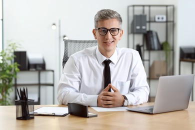 Photo of Portrait of businessman at table in office