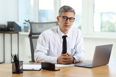 Photo of Portrait of businessman at table in office