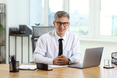 Photo of Portrait of businessman at table in office