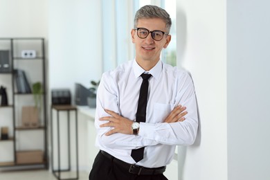 Photo of Portrait of businessman with crossed arms in office